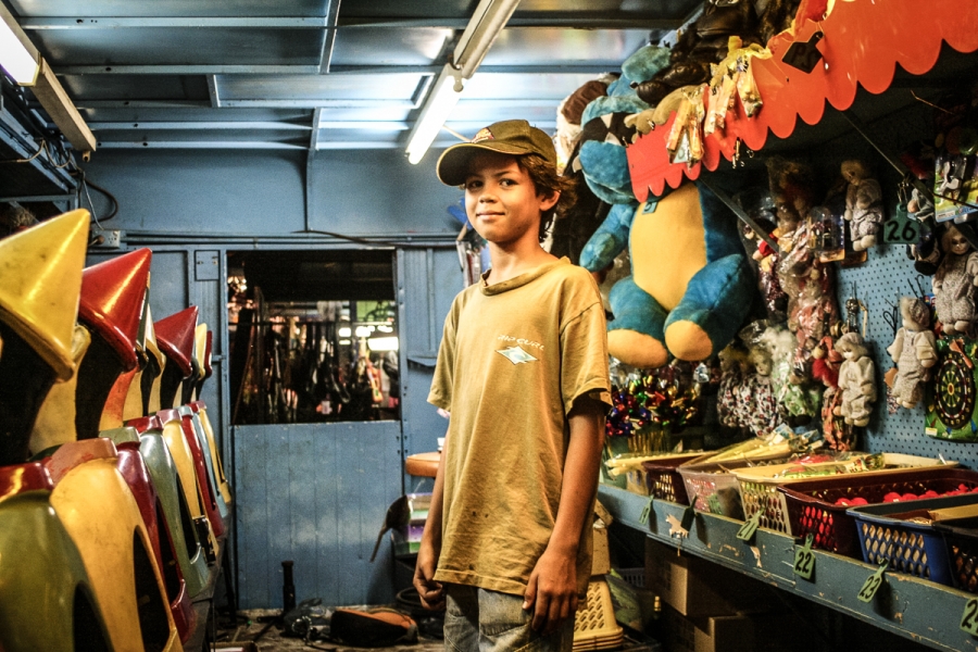 a boy on the night market at mindil beach in darwin australia stands among toys